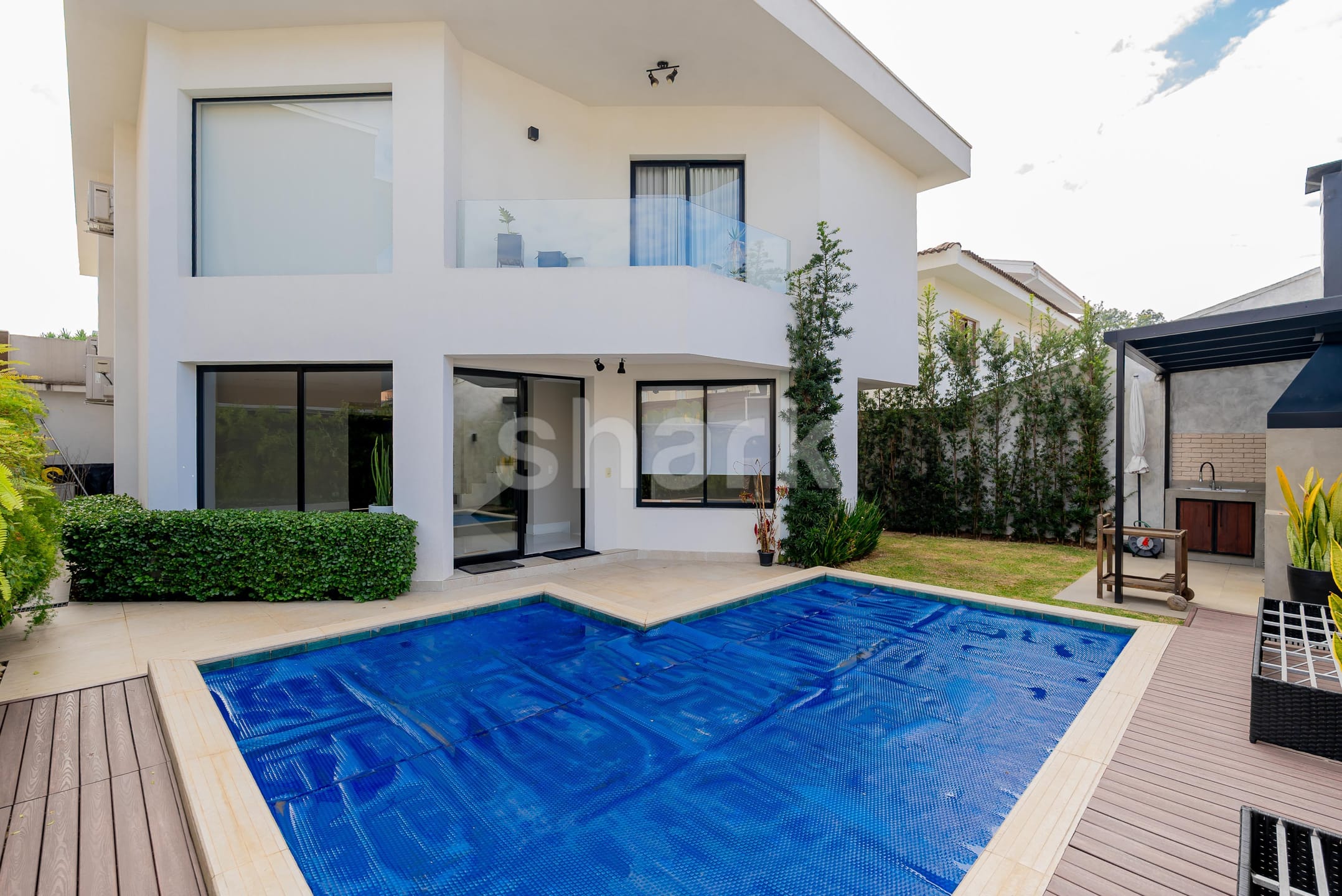 Fundos da casa com piscina, sacada e gramado