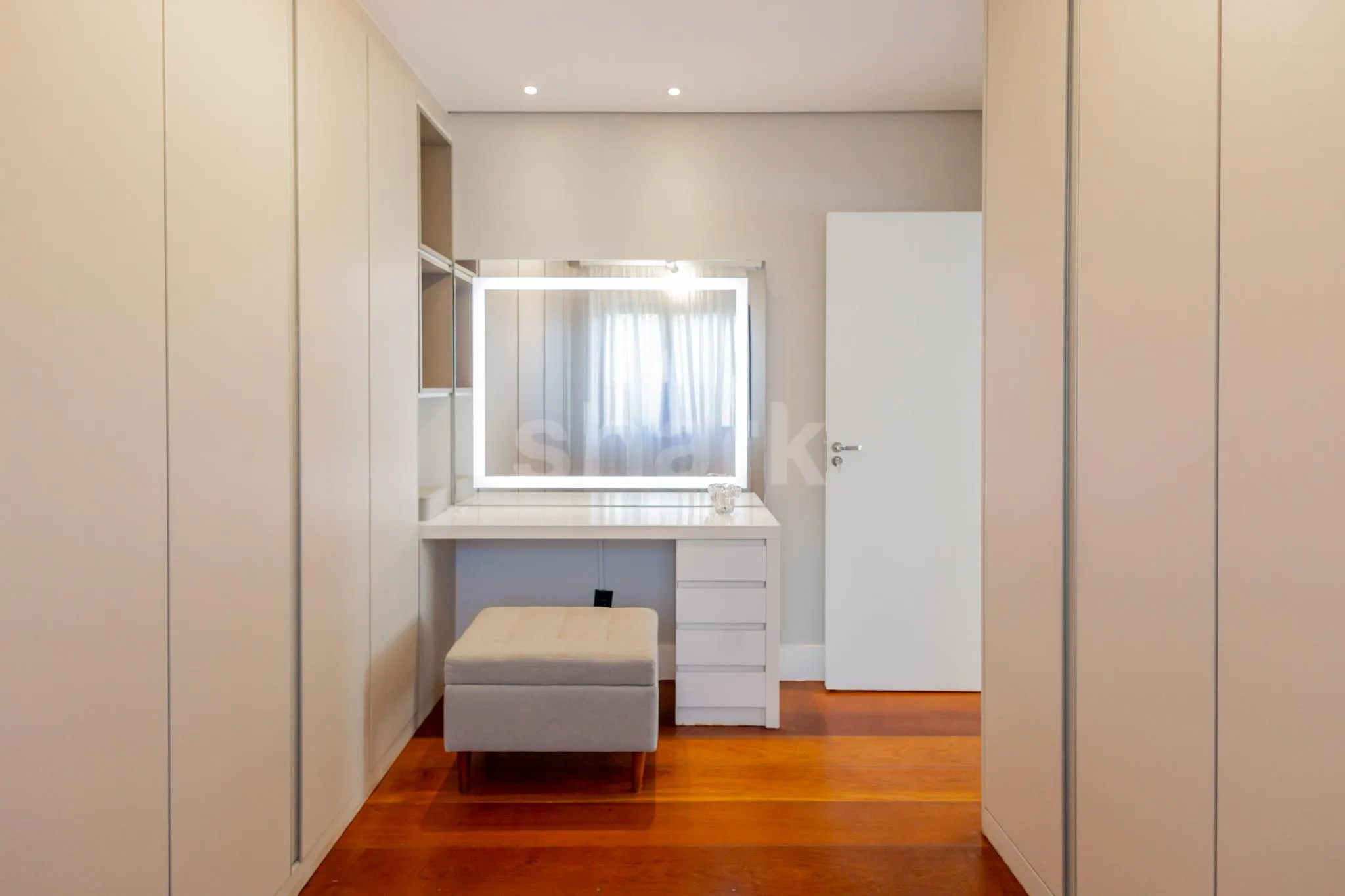 Closet com penteadeira iluminada e armários planejados